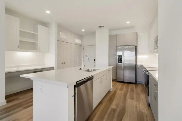a kitchen with kitchen island a sink stove and refrigerator