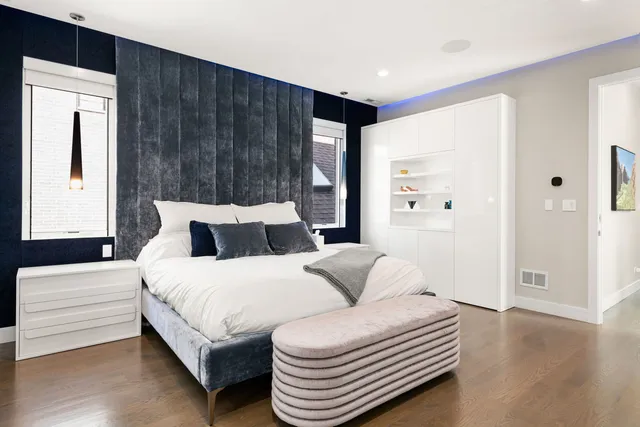 a spacious bedroom with a bed and wooden floor