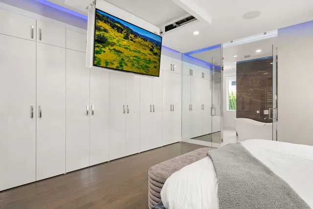 a spacious bedroom with a bed and a painting on the wall