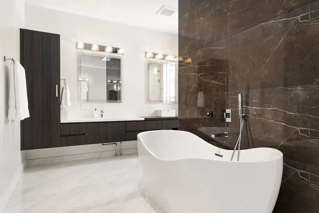 a bathroom with a bathtub a sink a mirror and a shower