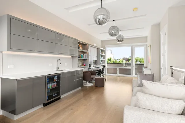a large white kitchen with a large window and stainless steel appliances