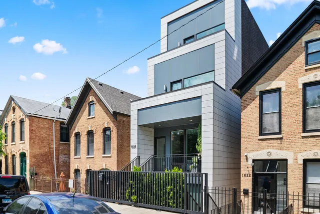 a view of a white house with large windows and a small yard