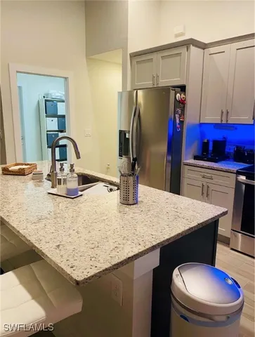 a kitchen with stainless steel appliances granite countertop a sink a refrigerator and a wooden floors