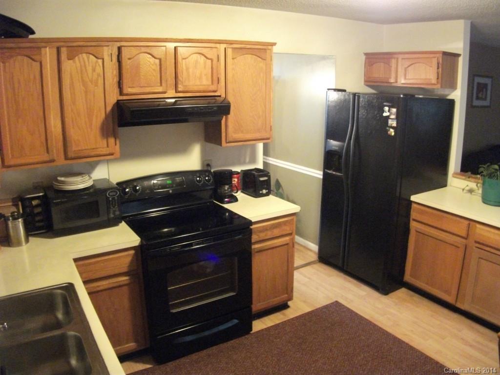 6007 Running Deer Road Charlotte, NC 28214 - Photo 7 of 23 a kitchen with granite countertop a refrigerator stove and cabinets