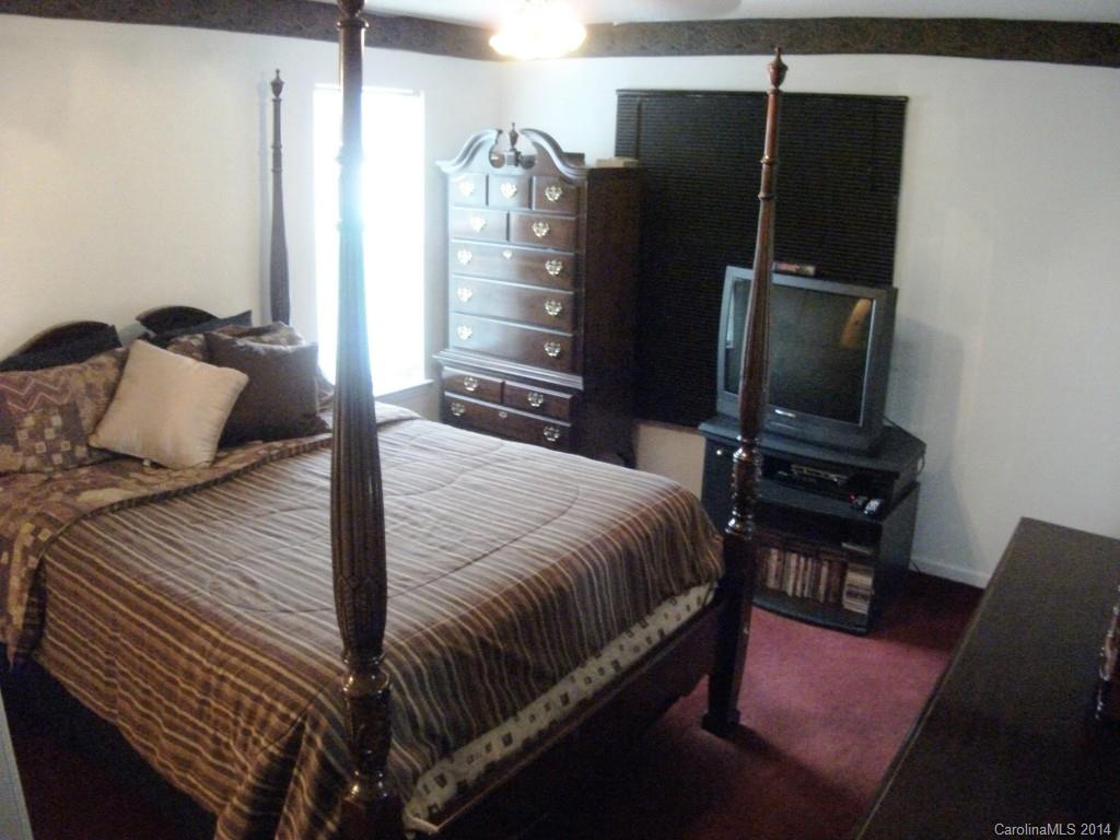 6007 Running Deer Road Charlotte, NC 28214 - Photo 10 of 23 a bedroom with a bed tv and a chair