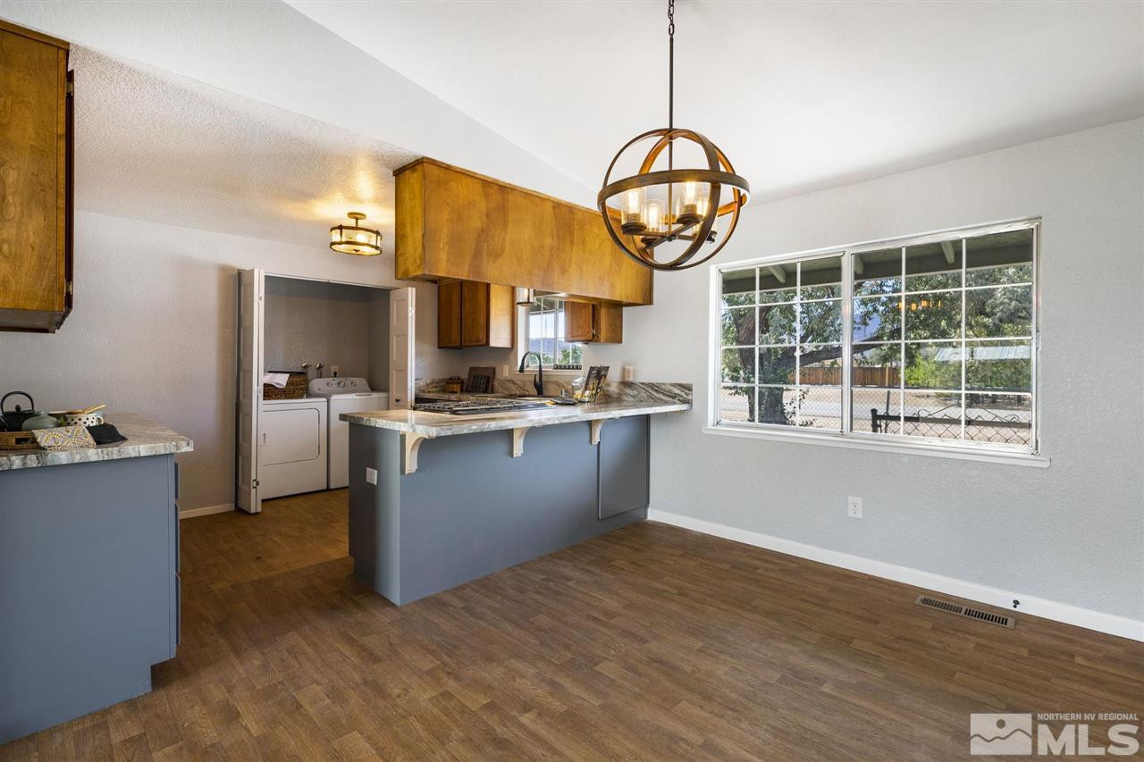 213 Ring Road Dayton, NV 89403 - Photo 8 of 40 a kitchen with stainless steel appliances granite countertop a stove a oven a large island with wooden floors and cabinets