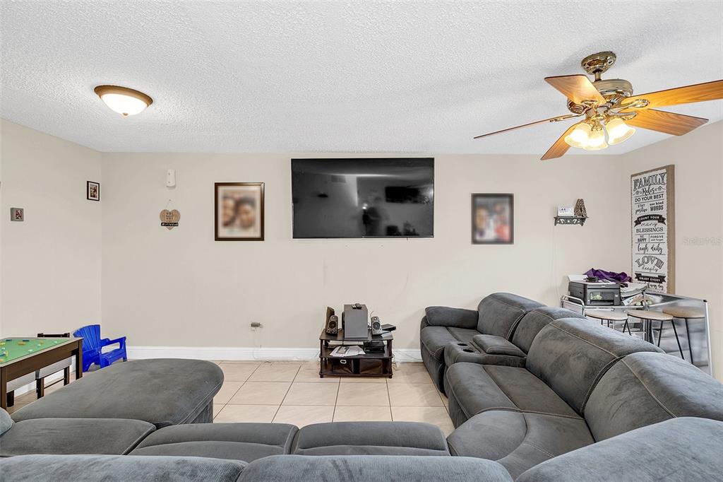 1612 Sandy Point Square, Unit 56 Orlando, FL 32807 - Photo 12 of 26 a living room with furniture and a flat screen tv