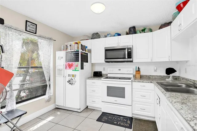 a kitchen with stainless steel appliances white cabinets a sink and a stove