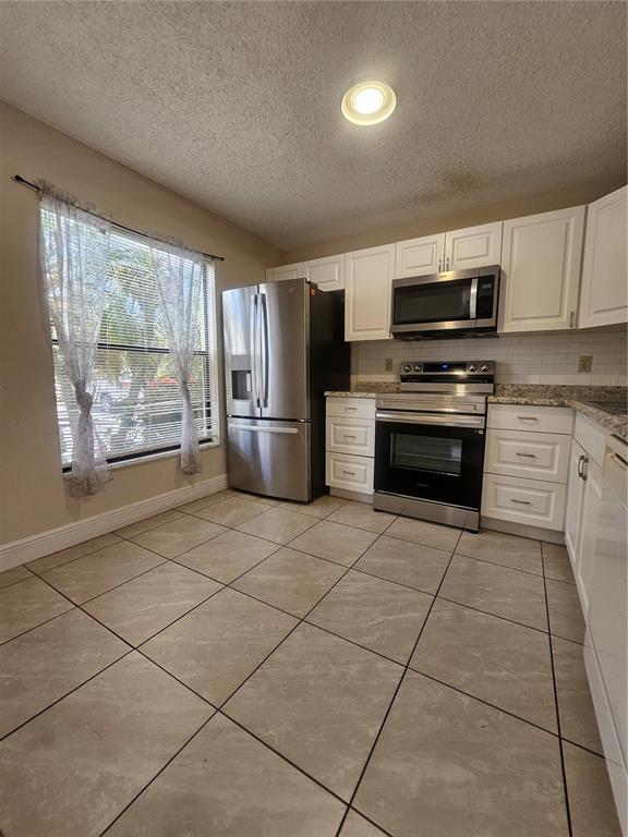1612 Sandy Point Square, Unit 56 Orlando, FL 32807 - Photo 8 of 26 a kitchen with stainless steel appliances a refrigerator sink and microwave