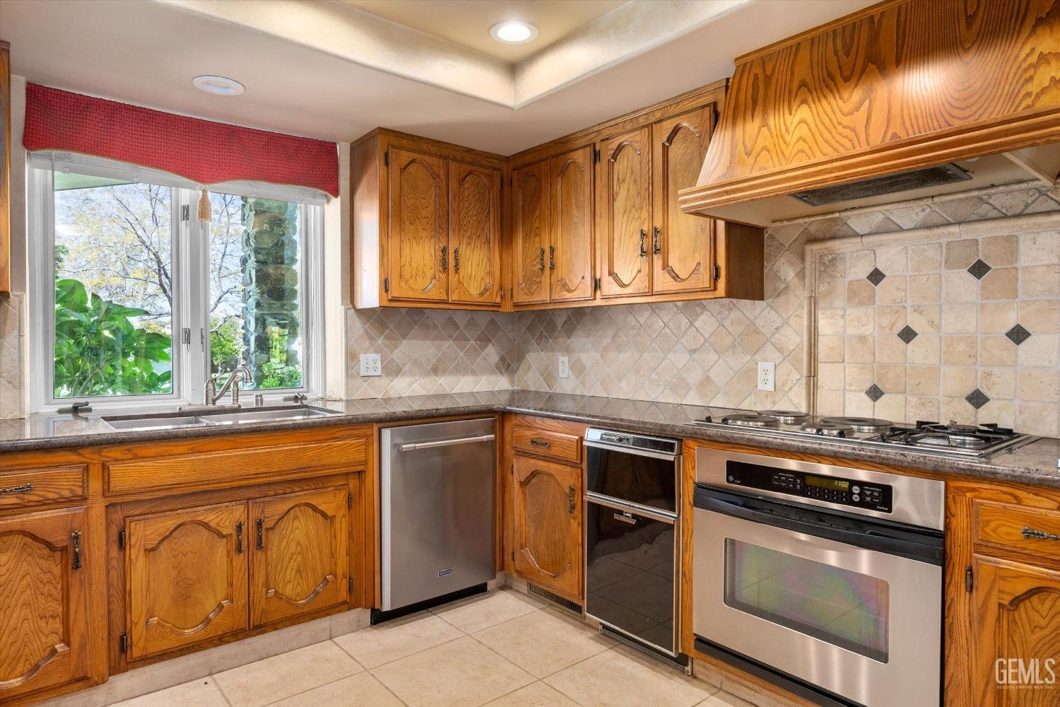 Undisclosed Address Bakersfield, CA 93313 - Photo 18 of 45 a kitchen with granite countertop a stove sink and cabinets