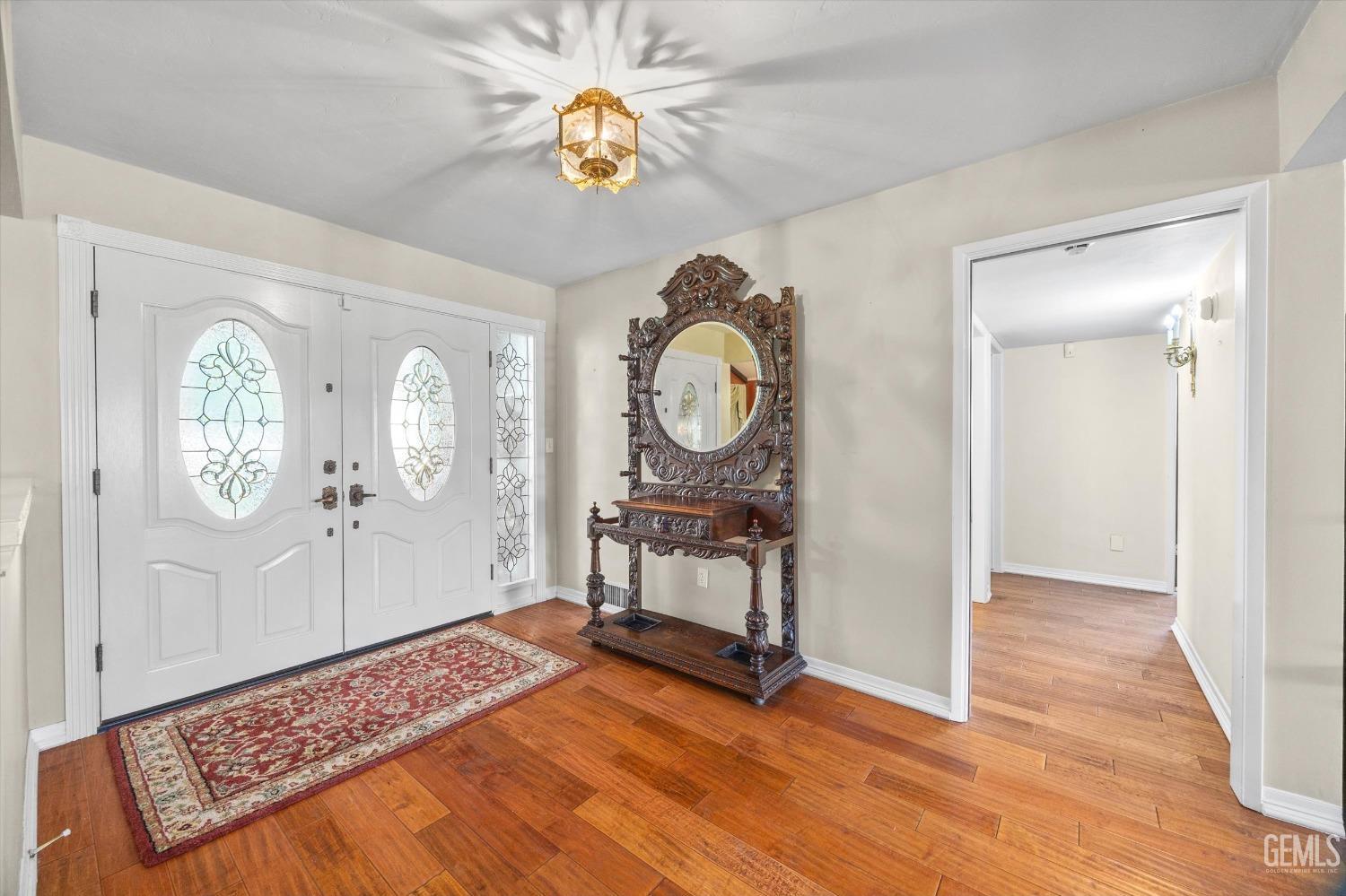 Undisclosed Address Bakersfield, CA 93313 - Photo 5 of 45 a view of a hallway with wooden floor and a bookshelf