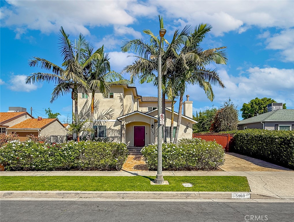 a front view of a house with a yard and potted plants