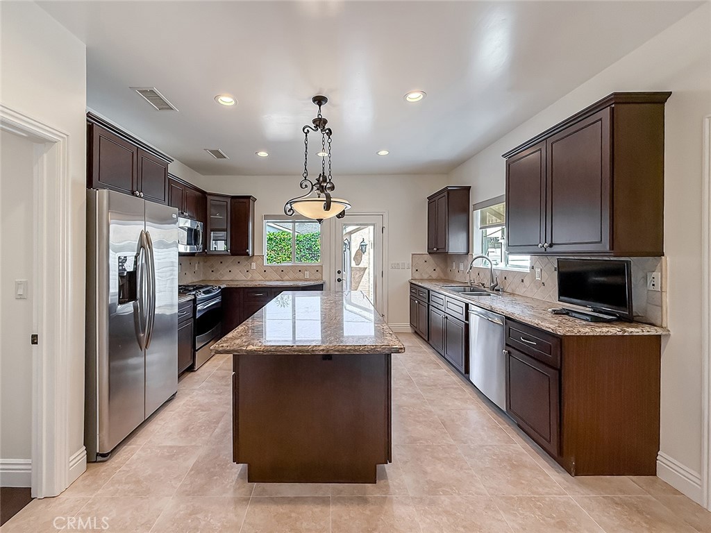 5960 Balcom Avenue Encino, CA 91316 - Photo 12 of 58 a large kitchen with stainless steel appliances kitchen island granite countertop a refrigerator a stove and a sink