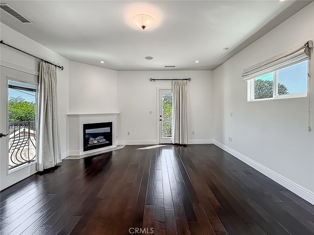 5960 Balcom Avenue Encino, CA 91316 - Photo 32 of 58 an empty room with wooden floor a fireplace and windows