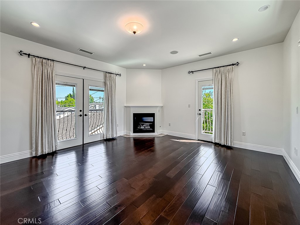 5960 Balcom Avenue Encino, CA 91316 - Photo 33 of 58 an empty room with wooden floor fireplace and windows