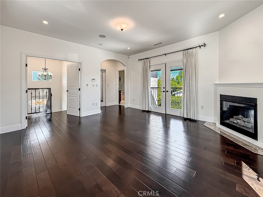 5960 Balcom Avenue Encino, CA 91316 - Photo 35 of 58 an empty room with wooden floor a fireplace and windows