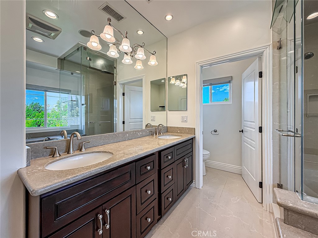 5960 Balcom Avenue Encino, CA 91316 - Photo 39 of 58 a spacious bathroom with a granite countertop sink a large mirror and a shower