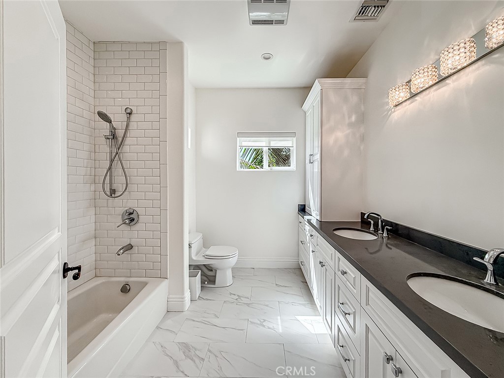 5960 Balcom Avenue Encino, CA 91316 - Photo 46 of 58 a spacious bathroom with a granite countertop tub sink a mirror a shower and a toilet