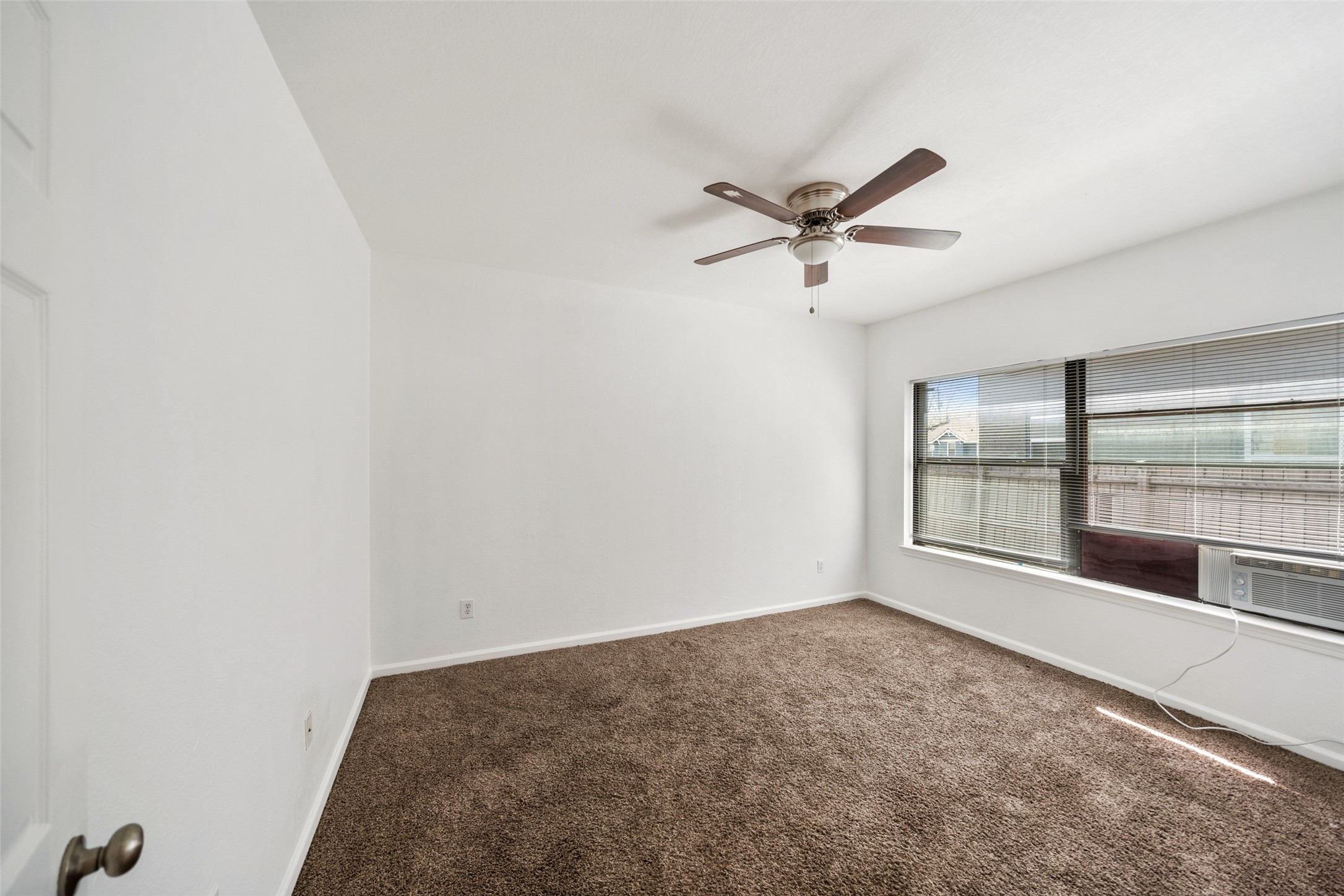 406 Quitman Street, Unit 2 Houston, TX 77009 - Photo 18 of 22 an empty room with chandelier fan and windows