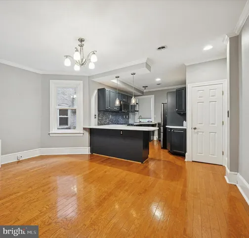 a view of kitchen with granite countertop cabinets and refrigerator