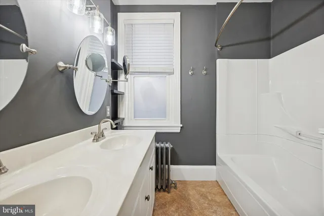 a bathroom with a tub sink and mirror