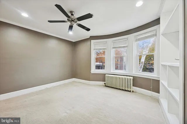 an empty room with a ceiling fan and windows