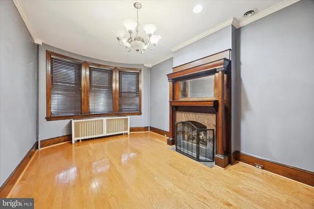 a view of an empty room with a fireplace and a window