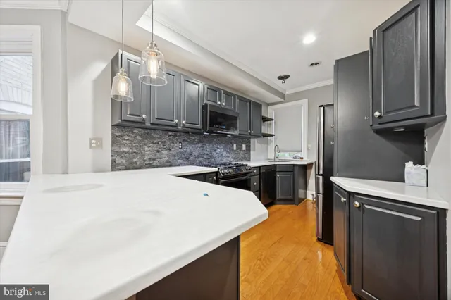 a kitchen with a sink a stove top oven a refrigerator and a cabinets