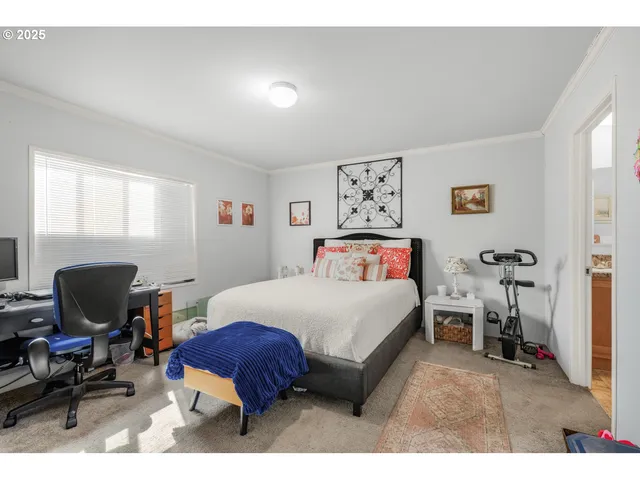 a bedroom with a bed and a view of living room