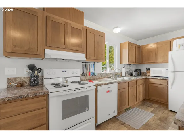 a kitchen with kitchen island granite countertop a sink stove and cabinets