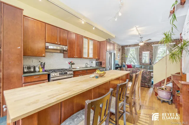 a view of a kitchen with kitchen island a stove a sink and a refrigerator