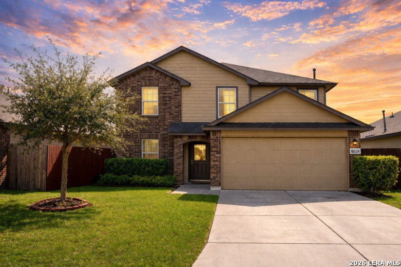a front view of a house with a yard and garage