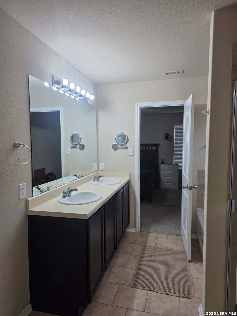 6024 Harvest Ranch San Antonio, TX 78244 - Photo 14 of 31 a bathroom with a double vanity sink and a mirror