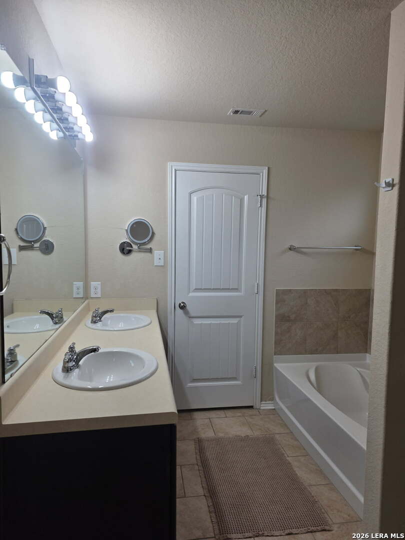 6024 Harvest Ranch San Antonio, TX 78244 - Photo 15 of 31 a bathroom with a sink a bathtub and a mirror