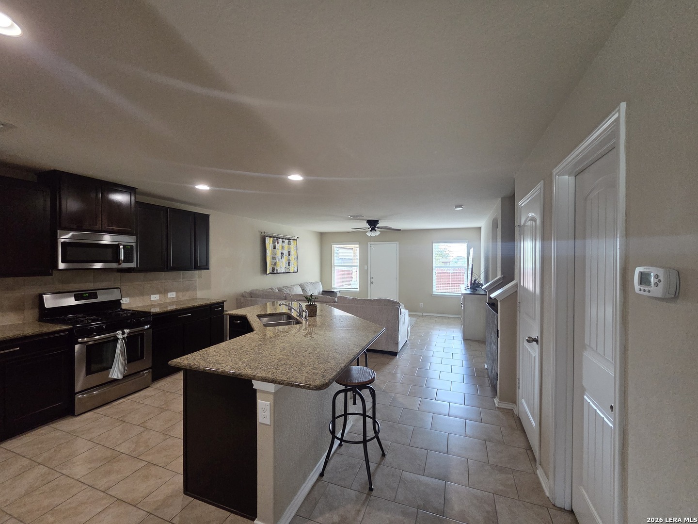 6024 Harvest Ranch San Antonio, TX 78244 - Photo 2 of 31 a kitchen with stainless steel appliances granite countertop a refrigerator a sink a stove and a microwave