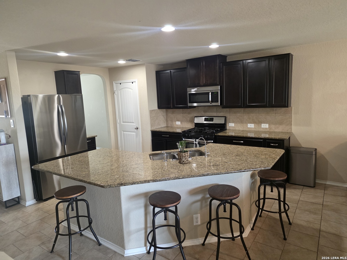 6024 Harvest Ranch San Antonio, TX 78244 - Photo 3 of 31 a kitchen with stainless steel appliances granite countertop a table chairs microwave and refrigerator