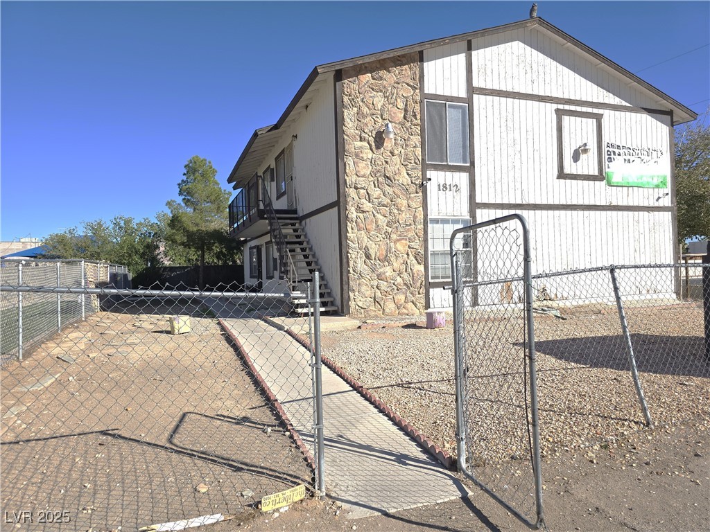 1812 Fulstone Way, Unit 3 Las Vegas, NV 89115 - Photo 4 of 12 View of property exterior with stone siding, a gate, and stairway
