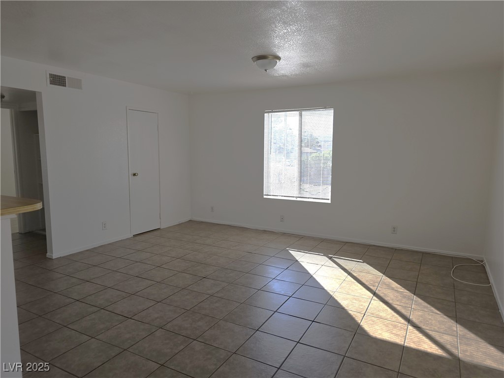 1812 Fulstone Way, Unit 3 Las Vegas, NV 89115 - Photo 6 of 12 Spare room with light tile patterned floors and a textured ceiling