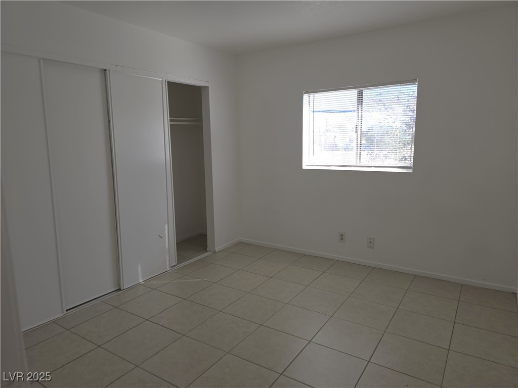 1812 Fulstone Way, Unit 3 Las Vegas, NV 89115 - Photo 7 of 12 Unfurnished bedroom featuring light tile patterned floors and a closet