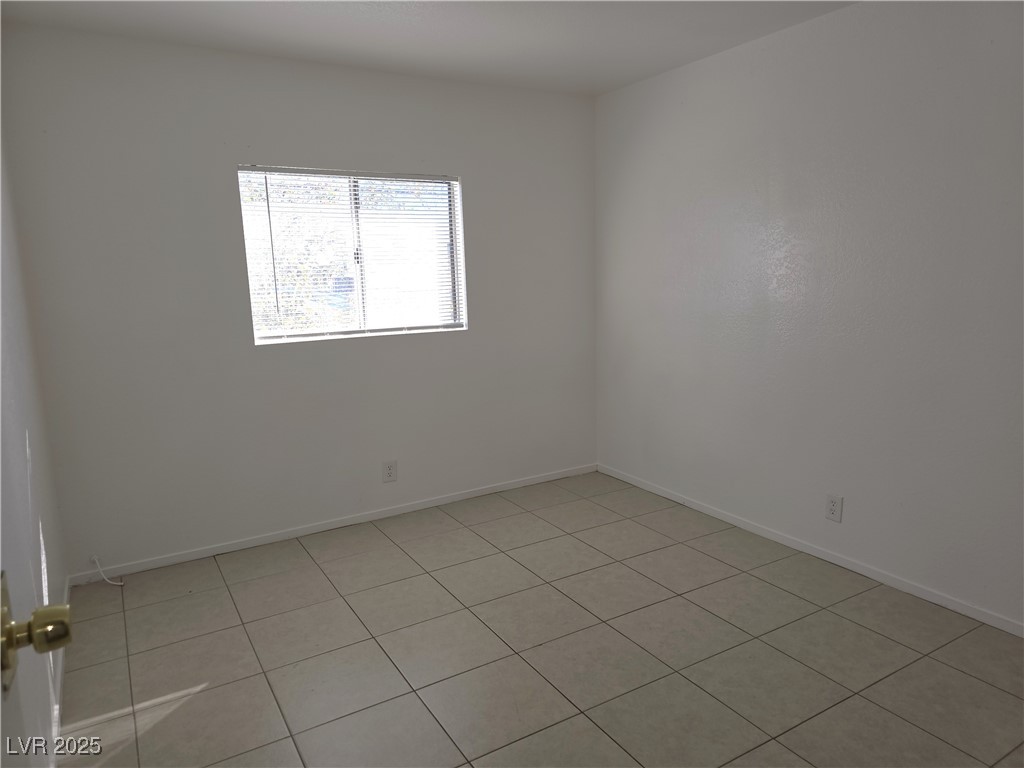 1812 Fulstone Way, Unit 3 Las Vegas, NV 89115 - Photo 8 of 12 Empty room featuring light tile patterned floors and baseboards