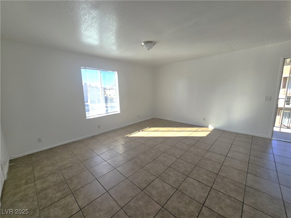 1812 Fulstone Way, Unit 3 Las Vegas, NV 89115 - Photo 10 of 12 Tiled spare room with a textured ceiling and baseboards