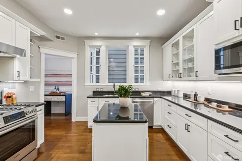 a kitchen with stainless steel appliances granite countertop a stove a sink and a refrigerator