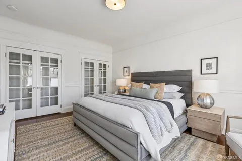 a glass vase with flowers on a table with wooden floor