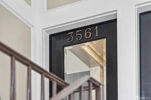 a view of a hallway with a door and furniture