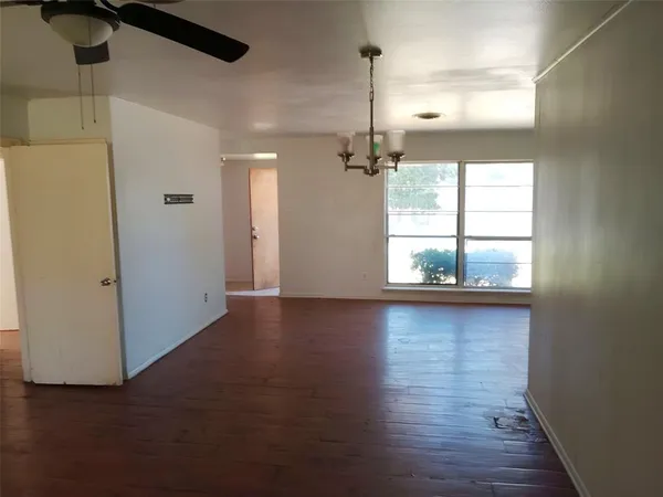 a view of a livingroom with wooden floor and a window