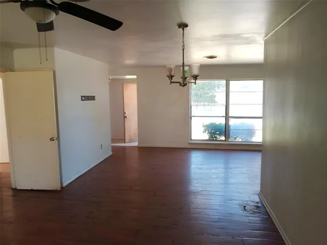 a view of a livingroom with wooden floor and a window