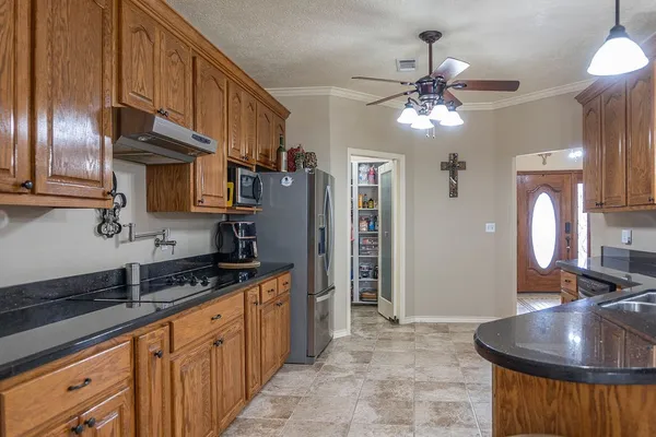 a kitchen with stainless steel appliances granite countertop a sink a stove and a refrigerator