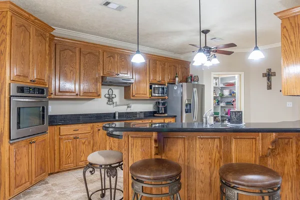 a kitchen with stainless steel appliances granite countertop a sink a stove and a refrigerator