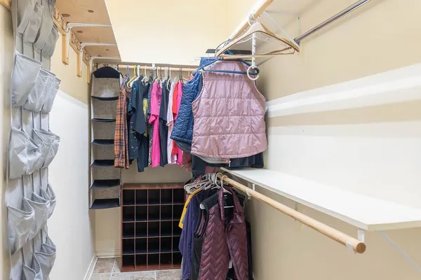 a view of walk in closet with clothes and shoes