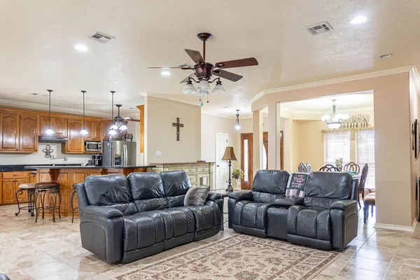a living room with furniture a ceiling fan and a chandelier